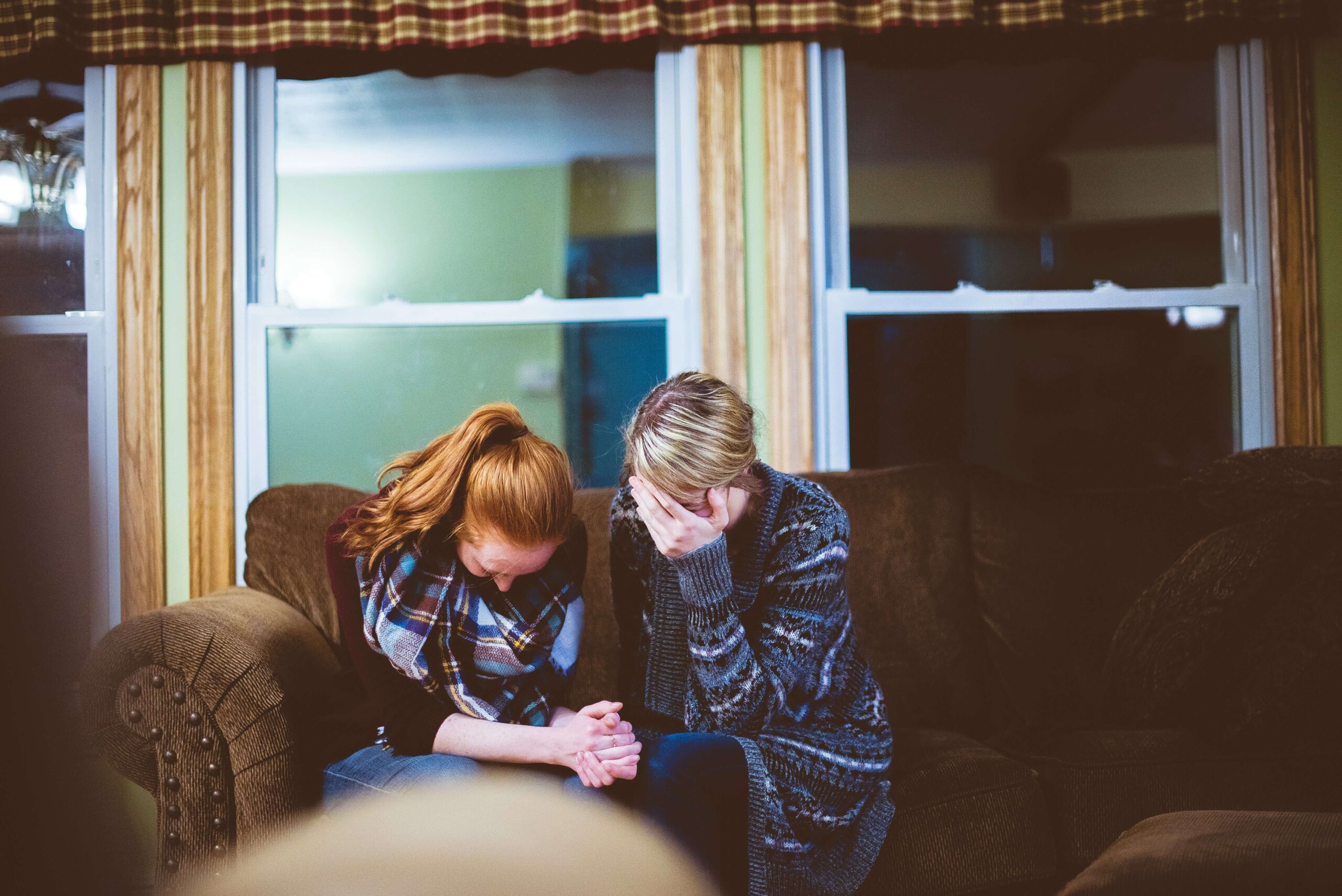 Two people on a couch supporting each other through grief and loss